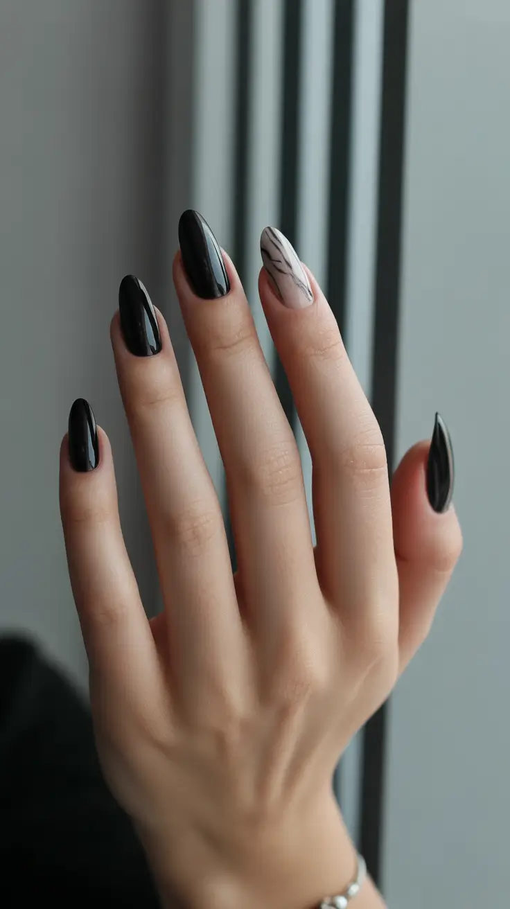 classy trendy spring nails 2026 Glossy Black Almond Nails with Modern Marble Accent