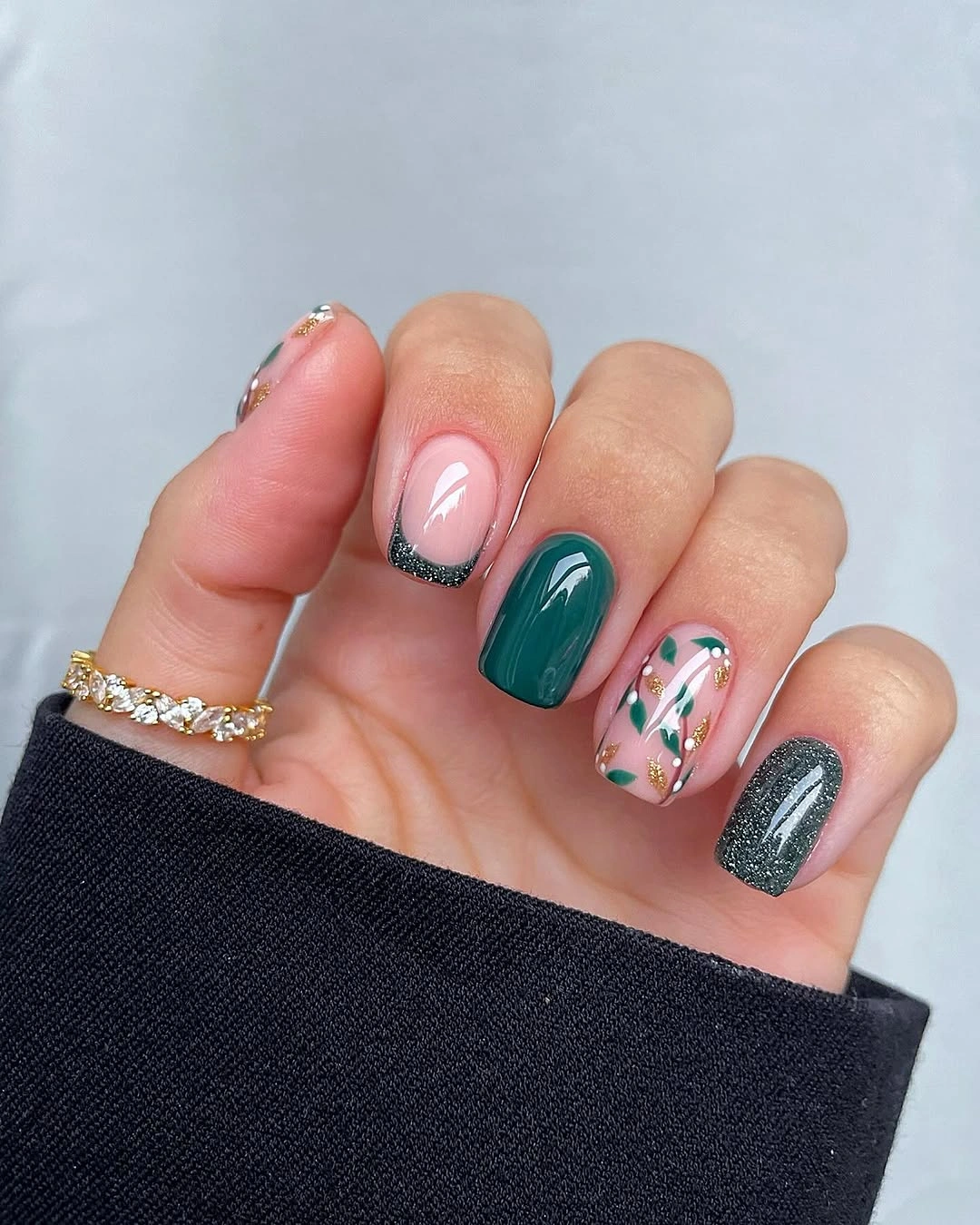 Short green and pink nails with botanical accents and charcoal glitter