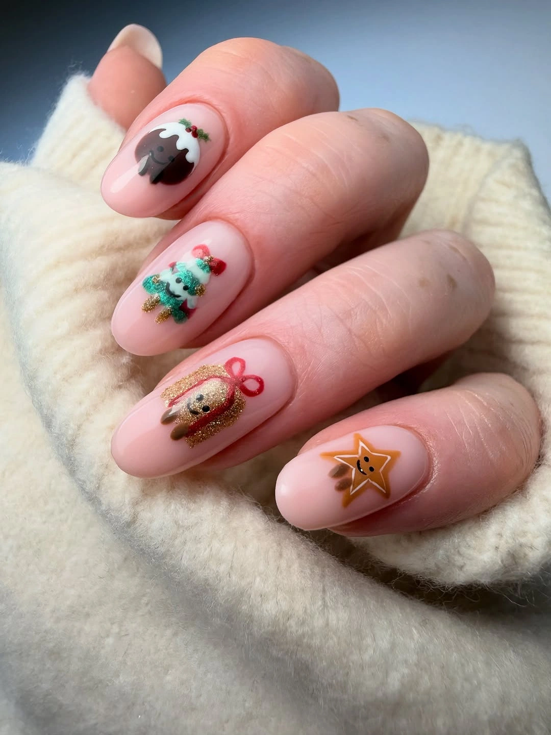 Pink almond nails with Christmas pudding, decorated tree, gift and star