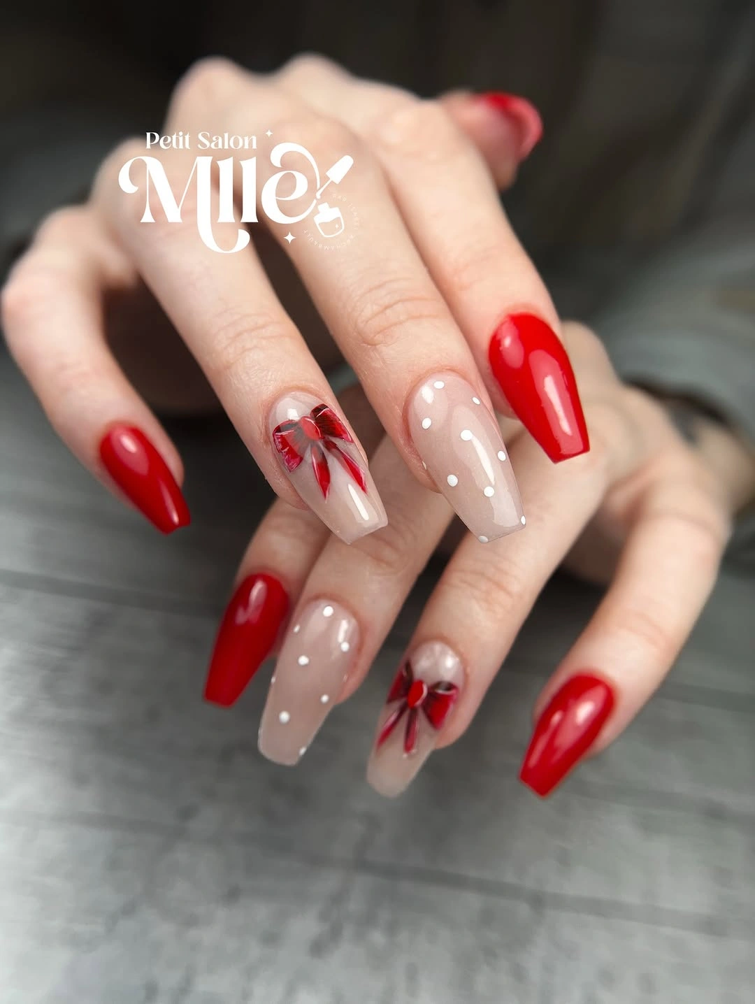 Long coffin nails with glossy red polish and delicate ribbon bow designs