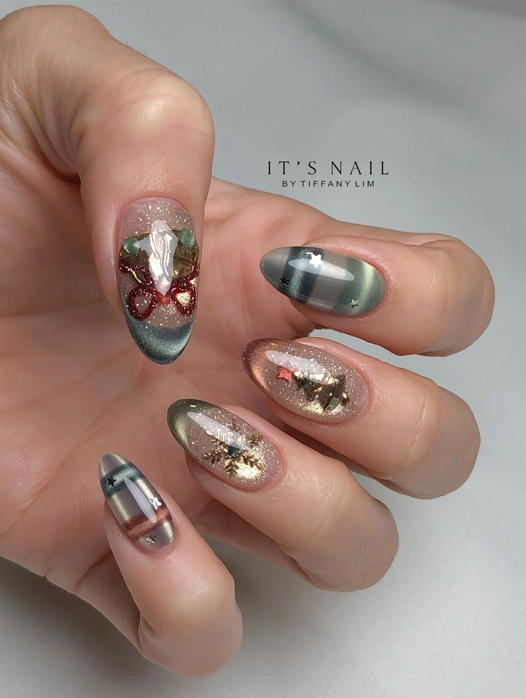 Almond nails with smoky silver plaid, champagne glitter, and small red accents