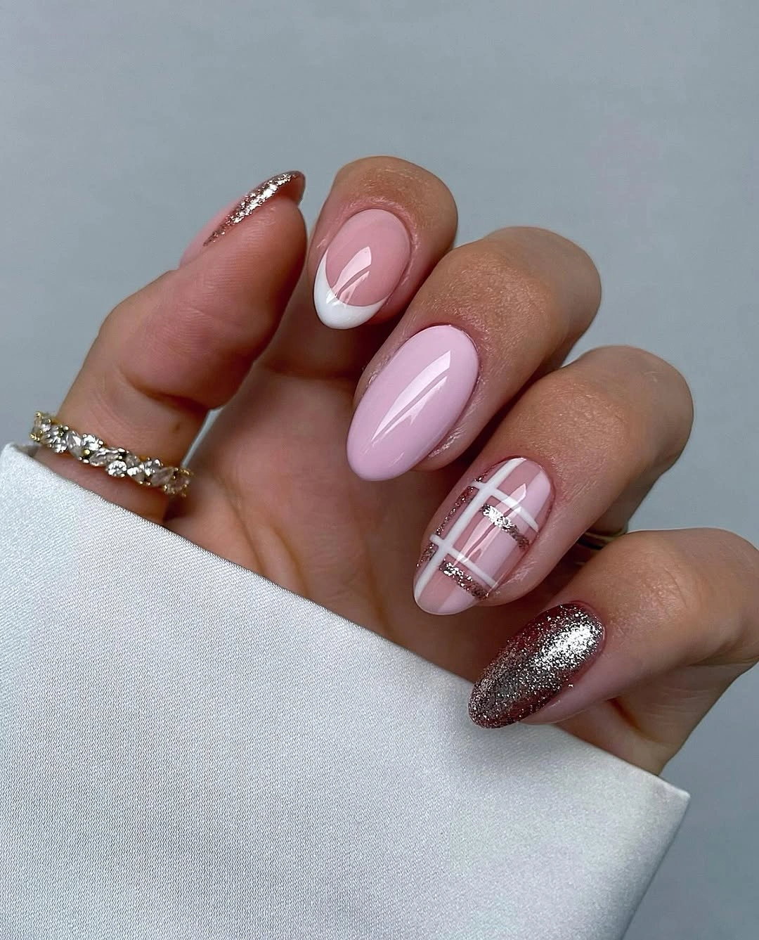 Soft pink almond nails with white French tips, plaid and metallic glitter