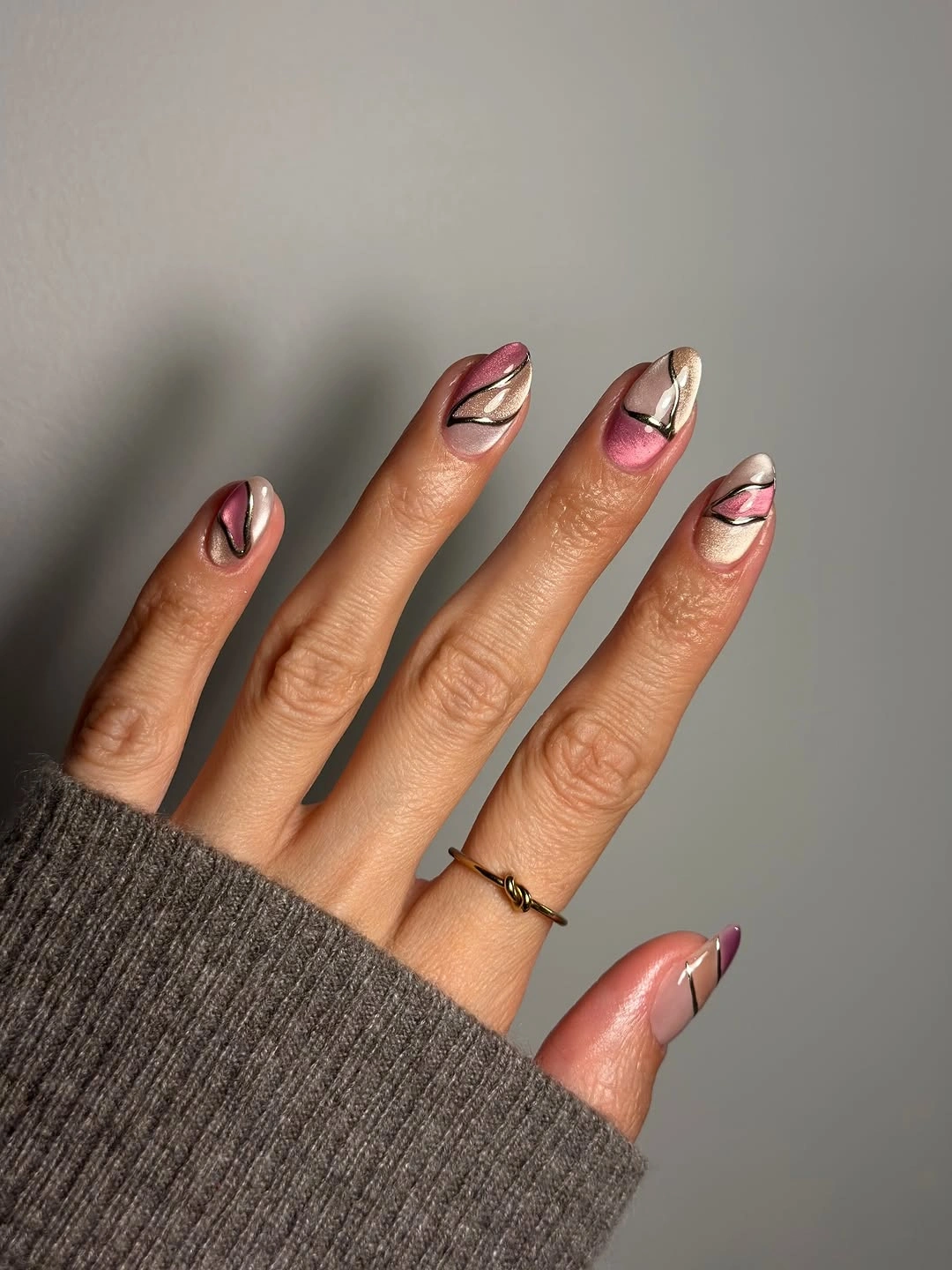Mauve and rose almond nails with sweeping reflective metallic lines