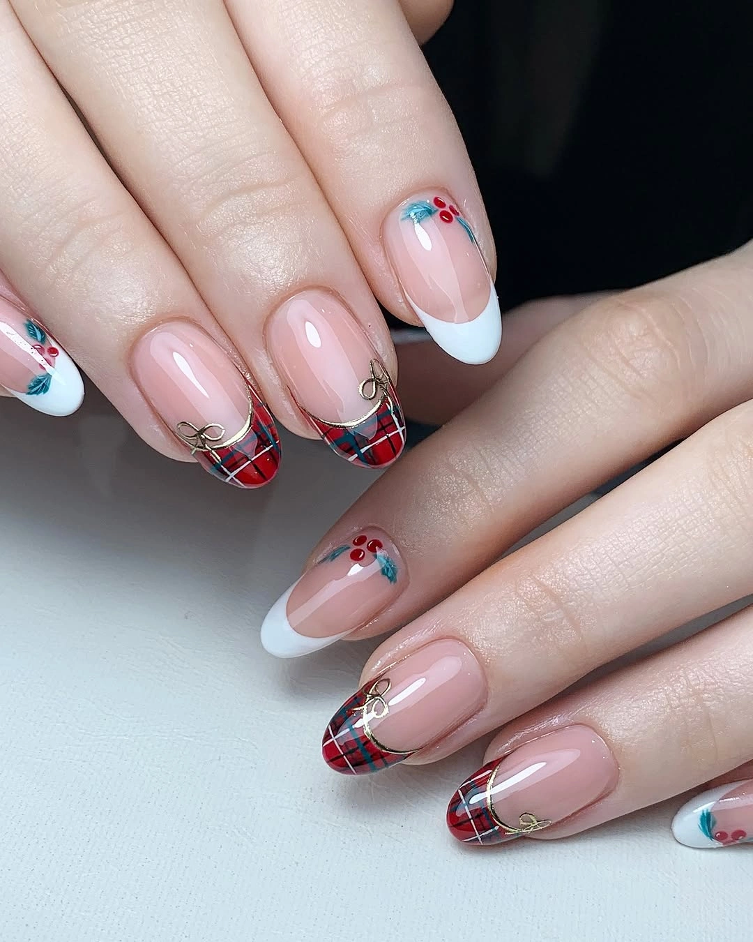Long pink nails with red plaid French tips and delicate floral accents