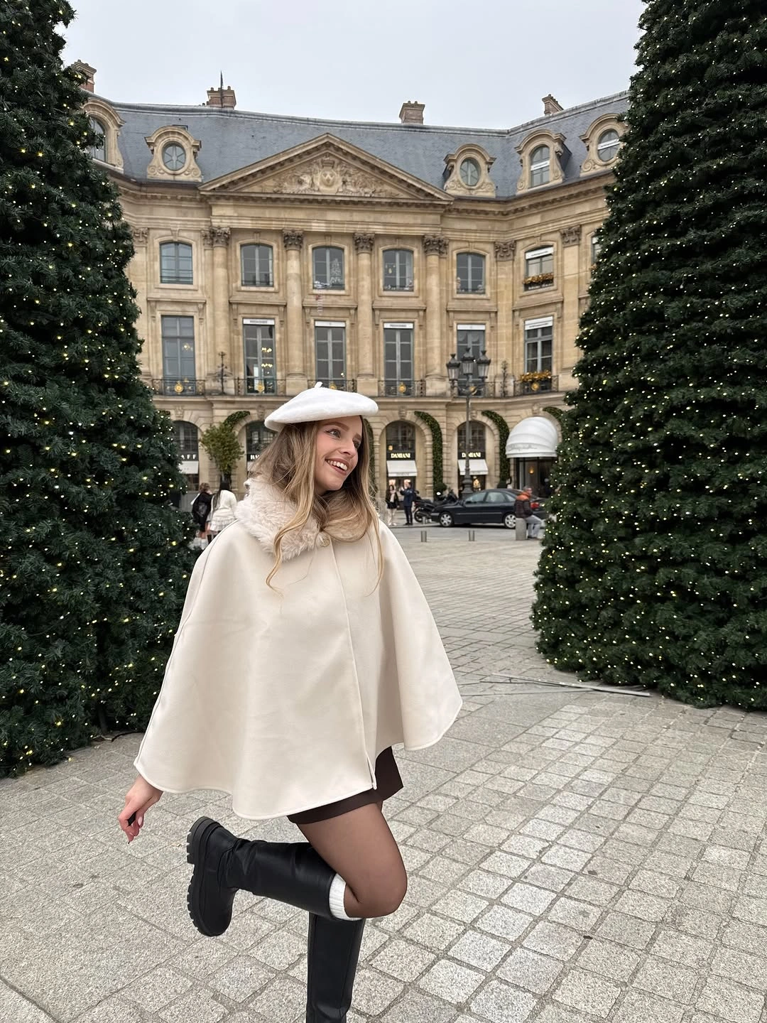 Cream white cape and beret styled with black tights and tall boots